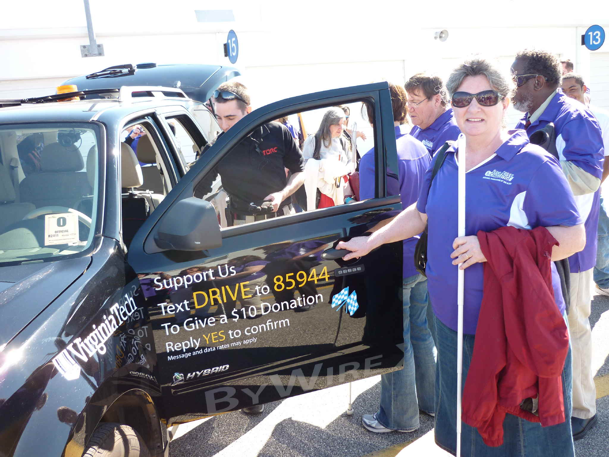 Pamela Glisson holding the door of an SUV challenge vehicle